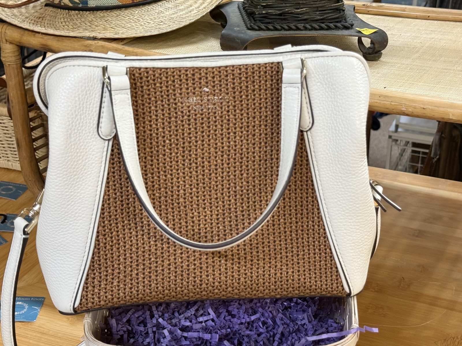 Designer purses, including a white and woven Kate Spade New York handbag.